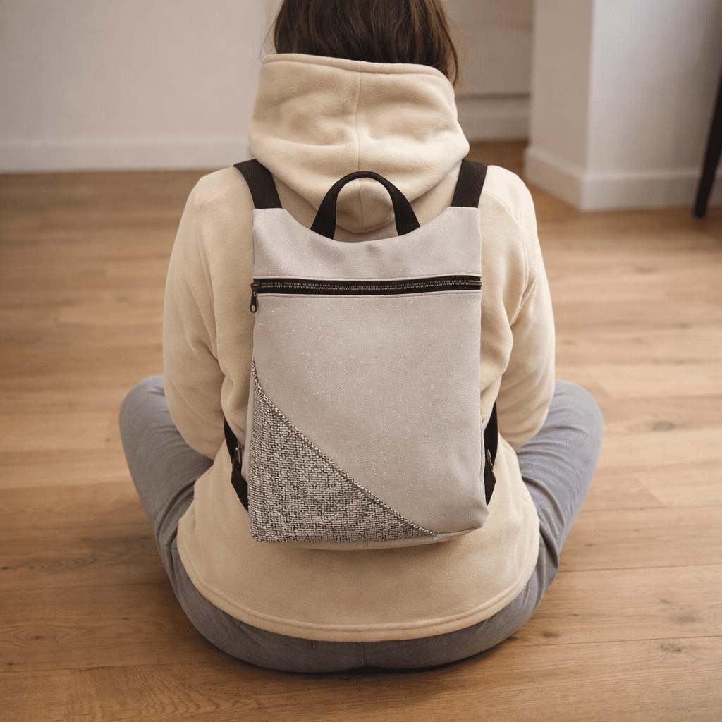 Zaino moderno handmade bicolore beige e grigio, design elegante con tasca frontale e dettagli minimal.